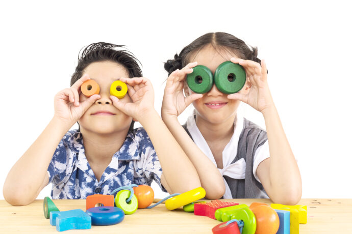 Asian boy and girl are happily playing colorful wood block toy